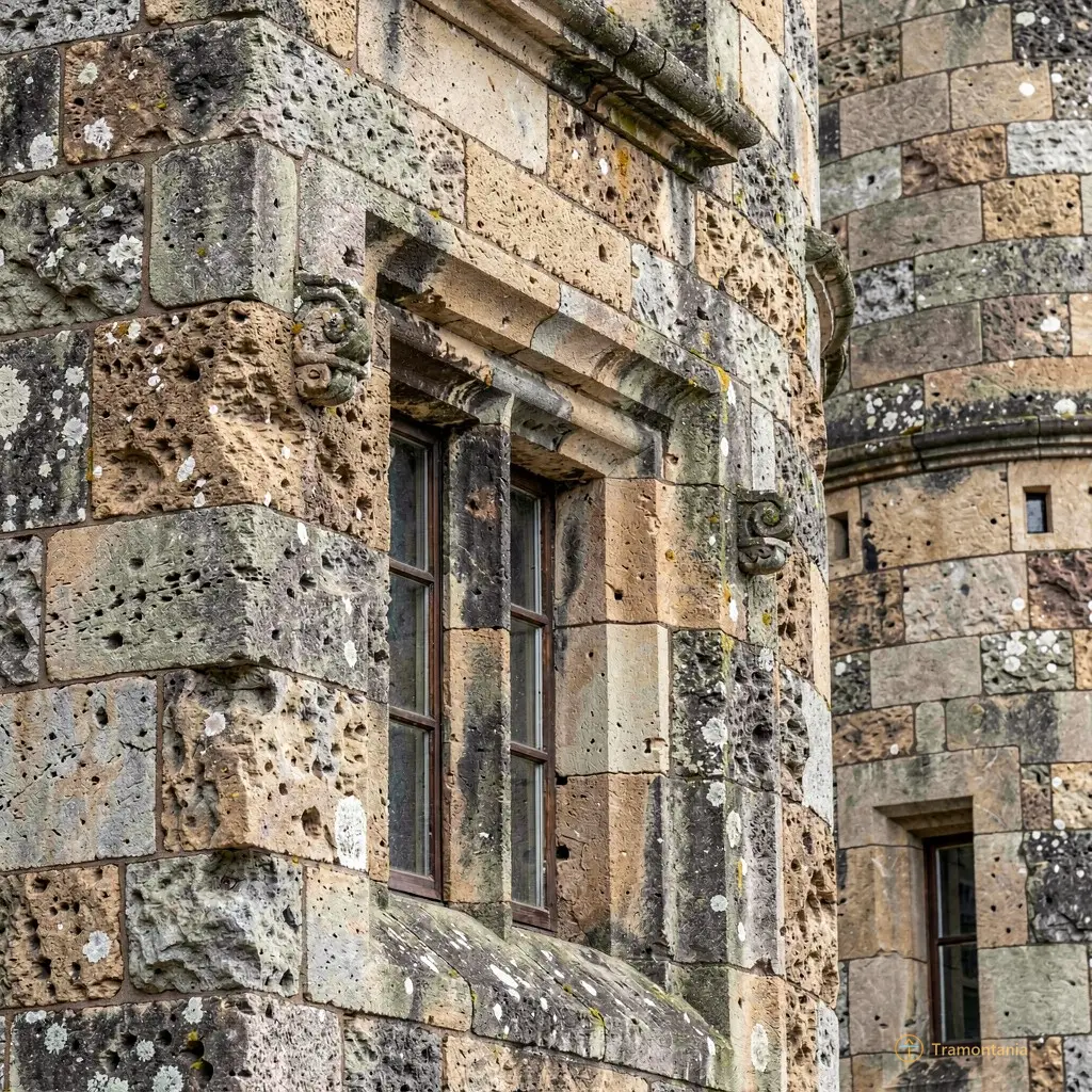 Close-up of weathered stone textures on the castle facade, highlighting centuries of erosion and history